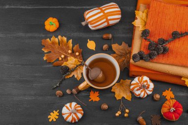 Bir fincan çay, el yapımı kumaş balkabakları, meşe palamutları, kozalakları, dökülen yapraklar ve zanaatlar için tekstil, yavaş yaşam ve mevsimsel konforu sembolize eden,