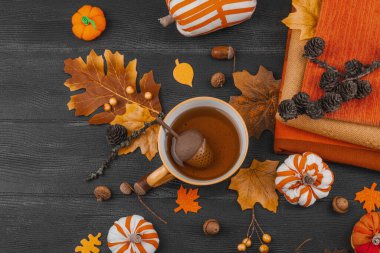 Bir fincan çay, el yapımı kumaş balkabakları, meşe palamutları, kozalakları, dökülen yapraklar ve zanaatlar için tekstil, yavaş yaşam ve mevsimsel konforu sembolize eden,