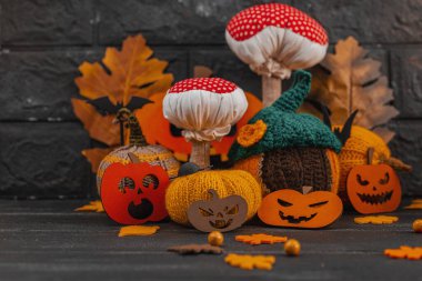 Karanlık Cadılar Bayramı atmosferik kompozisyonu. El yapımı örgü, tığ işi ve sonbahar dekoru. Balkabağı, mantar, dökülen yapraklar, fener valesi, böğürtlen. Yaratıcı festival hobisi, DIY dekorasyonları