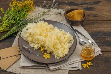 Tete de Moine peyniri, bal ve ahşap bir masada kurutulmuş bitkilerle kırsal bir hayat. Ilık ışık ve antika atmosfer eczacı tarzı, koyu arkaplan, kopyalama alanı