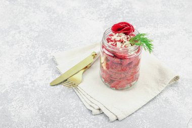 Dereotu ve kırmızı dolma biberle süslenmiş cam kavanozda vejetaryen pancar makarna salatası. Sağlıklı, enerjik ve bitkisel yemek hazırlama fikri hafif bir arkaplanda, boşluğu kopyala