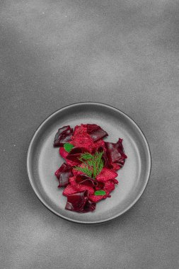 Taze dereotlu ve naneli vejetaryen pancar kökü makarnası siyah bir seramik kasede servis ediliyor. Sağlıklı, bitkisel ve bağırsak dostu gıda, kırsal tarz, siyah taş beton arka plan, üst görünüm