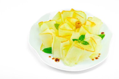 İnce dilimlenmiş karpuz carpaccio aperatifi taze nane ve balzamik sosla beyaz tabağa düşer. Gurme sağlıklı yemek için izole edilmiş gıda tasarımı, yakın çekim