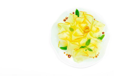 İnce dilimlenmiş karpuz carpaccio aperatifi taze nane ve balzamik sosla beyaz tabağa düşer. Gurme, sağlıklı yemek ve üst manzara için izole edilmiş gıda tasarımı.