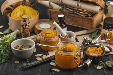 Kabak püresi, humus, bitkiler, kurutulmuş baharatlar, antika makas ve koyu ahşap arka planda antika nesnelerin yer aldığı taşralı natürmort hayat. Eczacı konsepti veya cadı ruhu, yaklaşın.