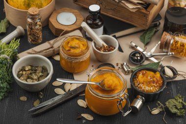 Kabak püresi, humus, bitkiler, kurutulmuş baharatlar, antika makas ve koyu ahşap arka planda antika nesnelerin yer aldığı taşralı natürmort hayat. Eczacı konsepti veya cadı ruhu, yaklaşın.