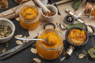 Kabak püresi, humus, bitkiler, kurutulmuş baharatlar, antika makas ve koyu ahşap arka planda antika nesnelerin yer aldığı taşralı natürmort hayat. Eczacı konsepti veya cadı ruhu, yaklaşın.