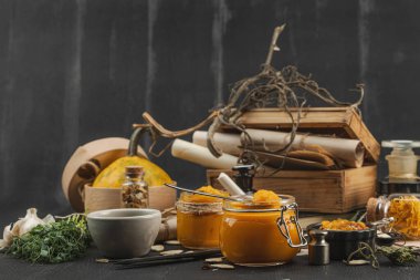 Kabak püresi, humus, bitkiler, kurutulmuş baharatlar, antika makas ve koyu ahşap arka planda antika nesnelerin yer aldığı taşralı natürmort hayat. Eczacı kavramı veya cadı ruhu, boşluğu kopyala