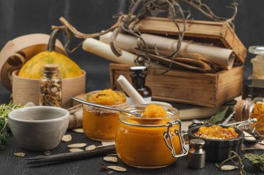 Kabak püresi, humus, bitkiler, kurutulmuş baharatlar, antika makas ve koyu ahşap arka planda antika nesnelerin yer aldığı taşralı natürmort hayat. Eczacı konsepti veya cadı ruhu, yaklaşın.