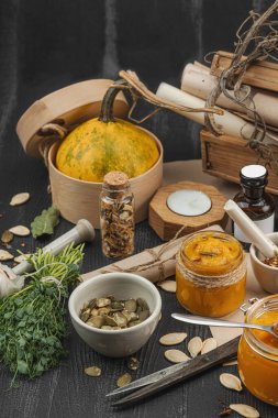 Kabak püresi, humus, bitkiler, kurutulmuş baharatlar, antika makas ve koyu ahşap arka planda antika nesnelerin yer aldığı taşralı natürmort hayat. Eczacı konsepti veya cadı ruhu, yaklaşın.