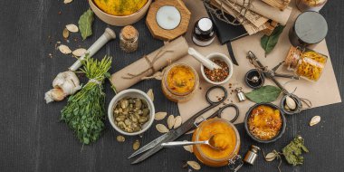 Kabak püresi, humus, bitkiler, kurutulmuş baharatlar, antika makas ve koyu ahşap arka planda antika nesnelerin yer aldığı taşralı natürmort hayat. Eczacı konsepti veya cadı ruhu, afiş biçimi