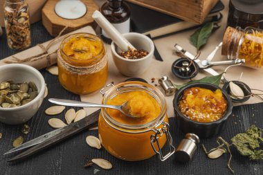 Kabak püresi, humus, bitkiler, kurutulmuş baharatlar, antika makas ve koyu ahşap arka planda antika nesnelerin yer aldığı taşralı natürmort hayat. Eczacı konsepti veya cadı ruhu, yaklaşın.