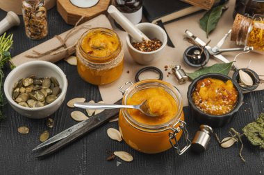 Kabak püresi, humus, bitkiler, kurutulmuş baharatlar, antika makas ve koyu ahşap arka planda antika nesnelerin yer aldığı taşralı natürmort hayat. Eczacı konsepti veya cadı ruhu, yaklaşın.