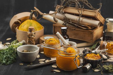 Kabak püresi, humus, bitkiler, kurutulmuş baharatlar, antika makas ve koyu ahşap arka planda antika nesnelerin yer aldığı taşralı natürmort hayat. Eczacı konsepti veya cadı ruhu, yaklaşın.