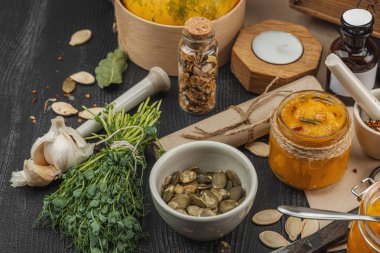 Kabak püresi, humus, bitkiler, kurutulmuş baharatlar, antika makas ve koyu ahşap arka planda antika nesnelerin yer aldığı taşralı natürmort hayat. Eczacı konsepti veya cadı ruhu, yaklaşın.