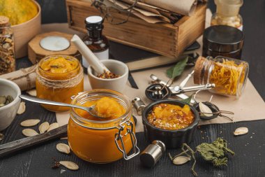 Kabak püresi, humus, bitkiler, kurutulmuş baharatlar, antika makas ve koyu ahşap arka planda antika nesnelerin yer aldığı taşralı natürmort hayat. Eczacı konsepti veya cadı ruhu, yaklaşın.