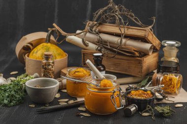 Kabak püresi, humus, bitkiler, kurutulmuş baharatlar, antika makas ve koyu ahşap arka planda antika nesnelerin yer aldığı taşralı natürmort hayat. Eczacı konsepti veya cadı ruhu, yaklaşın.