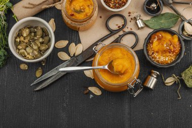 Kabak püresi, humus, bitkiler, kurutulmuş baharatlar, antika makas ve koyu ahşap arka planda antika nesnelerin yer aldığı taşralı natürmort hayat. Eczacı konsepti veya cadı ruhu, üst görünüm