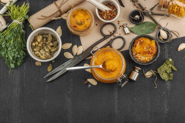 Kabak püresi, humus, bitkiler, kurutulmuş baharatlar, antika makas ve koyu ahşap arka planda antika nesnelerin yer aldığı taşralı natürmort hayat. Eczacı konsepti veya cadı ruhu, üst görünüm