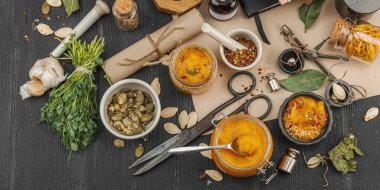 Kabak püresi, humus, bitkiler, kurutulmuş baharatlar, antika makas ve koyu ahşap arka planda antika nesnelerin yer aldığı taşralı natürmort hayat. Eczacı konsepti veya cadı ruhu, afiş biçimi