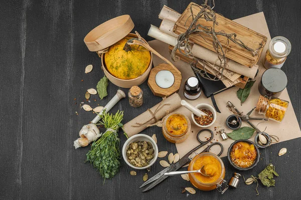 Kabak püresi, humus, bitkiler, kurutulmuş baharatlar, antika makas ve koyu ahşap arka planda antika nesnelerin yer aldığı taşralı natürmort hayat. Eczacı konsepti veya cadı ruhu, üst görünüm