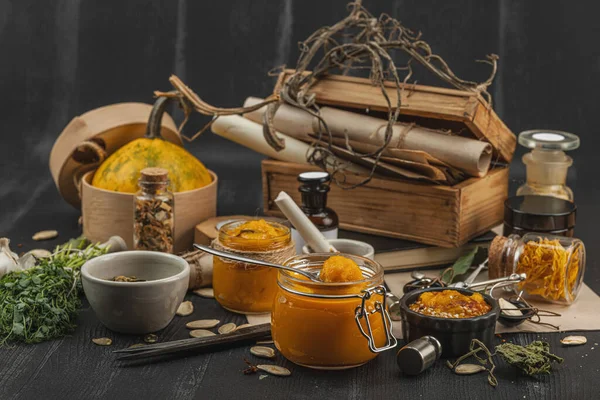 Kabak püresi, humus, bitkiler, kurutulmuş baharatlar, antika makas ve koyu ahşap arka planda antika nesnelerin yer aldığı taşralı natürmort hayat. Eczacı konsepti veya cadı ruhu, yaklaşın.