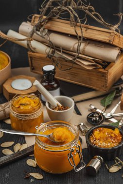 Kabak püresi, humus, bitkiler, kurutulmuş baharatlar, antika makas ve koyu ahşap arka planda antika nesnelerin yer aldığı taşralı natürmort hayat. Eczacı konsepti veya cadı ruhu, yaklaşın.