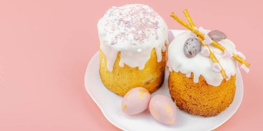 Geleneksel Paskalya pastaları, beyaz kremalı ve tabakta renkli yumurtalar serpiştirilmiş. Pembe arka planda tavşanları ve laleleri olan şenlikli bir kompozisyon. Ev yapımı tatil pişirme konsepti, afiş biçimi