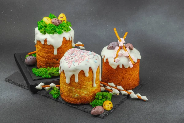 Yenilebilir yosun yuvası, çikolata yumurtası ve el yapımı söğüt dallarıyla süslenmiş paskalya pastaları. Siyah taş zemin üzerinde tavşan figürleri olan geleneksel şenlikli tatlı, kopyalama alanı