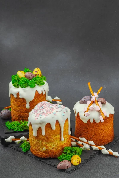 Yenilebilir yosun yuvası, çikolata yumurtası ve el yapımı söğüt dallarıyla süslenmiş paskalya pastaları. Siyah taş zemin üzerinde tavşan figürleri olan geleneksel şenlikli tatlı, kopyalama alanı