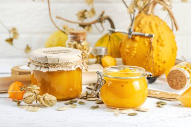 Antika eczacılık tarzında sağlıklı gıda konsepti. Ev yapımı kabak püresi ve beyaz ahşap bir masada cam kavanozlarda humus. Balkabağı, kurutulmuş zıpzıp ve bitki özü ile kırsal sonbahar natürmortu, kopyalama alanı
