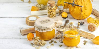 Antika eczacılık tarzında sağlıklı gıda konsepti. Ev yapımı balkabağı püresi, beyaz ahşap bir masada cam kavanozlarda humus. Balkabağı, kurutulmuş zıpzıp ve bitki salgısı ve pankart formatlı kırsal sonbahar yaşamı