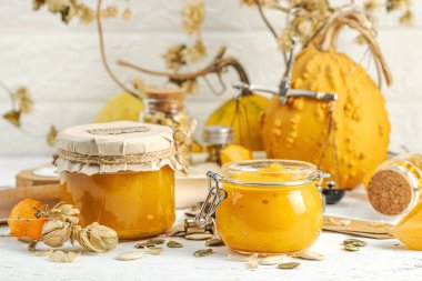 Antika eczacılık tarzında sağlıklı gıda konsepti. Ev yapımı kabak püresi ve beyaz ahşap bir masada cam kavanozlarda humus. Balkabağı, kurutulmuş zıpzıp ve bitki özü ile kırsal sonbahar natürmortu, kopyalama alanı