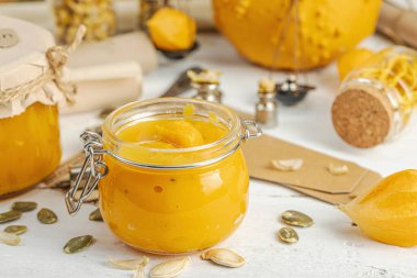 Antika eczacılık tarzında sağlıklı gıda konsepti. Ev yapımı kabak püresi ve beyaz ahşap bir masada cam kavanozlarda humus. Kabak, kurutulmuş zıpzıp ve bitki örtüsüyle dolu kırsal bir sonbahar hayatı. Kapan.