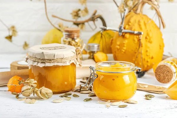 Antika eczacılık tarzında sağlıklı gıda konsepti. Ev yapımı kabak püresi ve beyaz ahşap bir masada cam kavanozlarda humus. Balkabağı, kurutulmuş zıpzıp ve bitki özü ile kırsal sonbahar natürmortu, kopyalama alanı