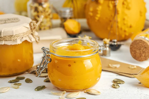 Antika eczacılık tarzında sağlıklı gıda konsepti. Ev yapımı kabak püresi ve beyaz ahşap bir masada cam kavanozlarda humus. Kabak, kurutulmuş zıpzıp ve bitki örtüsüyle dolu kırsal bir sonbahar hayatı. Kapan.