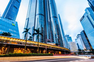 Ofis gökdelen binaları ve otoyollarda yoğun trafik. Central, Hong Kong 'da bulanık araba ışık yolları var..