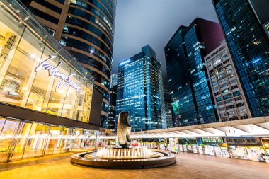 Arkasında gökdelenler bulunan Exchange Meydanı Forumu (podyum seviyesi). Sergide çok sayıda finans kurumu ve Hong Kong Borsası yer alıyor.