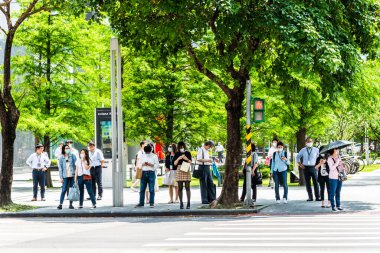 Taipei, Tayvan - 4 Mayıs 2020: Bazı yayalar kendilerini koronavirüsten (COVID-19) korumak için yüz maskesi takıyorlar Tayvan 'ın Taipeis Xinyi ilçesinde karşıdan karşıya geçiyorlar..