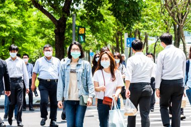 Kendilerini koronavirüsten (COVID-19) korumak için yüz maskesi takan bazı yayalar Tayvan 'ın Taipeis Xinyi bölgesinde karşıdan karşıya geçiyorlar..