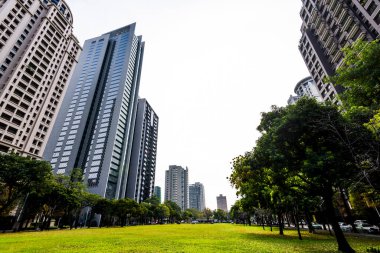 Tayvan 'ın Taichung kentindeki yeşil alan ve modern binaların alçak açılı görüntüsü. Ulusal Taichung Tiyatrosu yakınında..