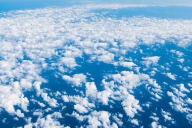 Uçuş sırasında mavi gökyüzü ve beyaz bulutların görüntüsü