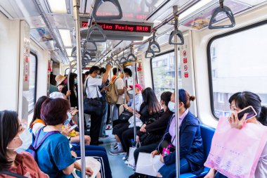 Tayvan 'ın Taipei kentindeki toplu hızlı ulaşım sisteminde kendilerini koronavirüsten (COVID-19) korumak için yüz maskesi takan yolcular. 