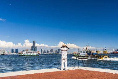 Manzarayı ziyaret eden turistler Kaohsiung, Tayvan limanında fotoğraf çekiyorlar..