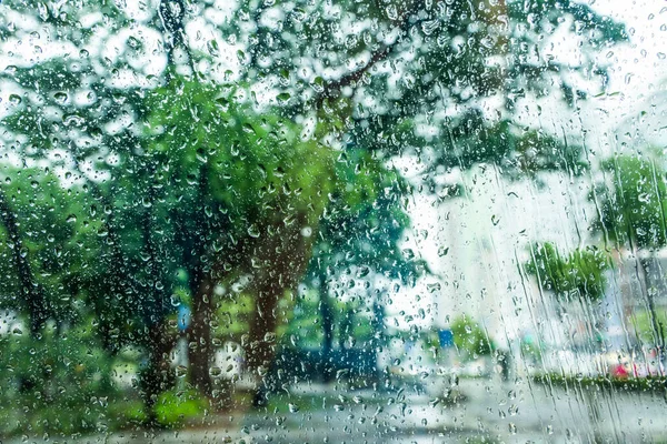 通りの景色を背景に窓に雨が降る — ストック写真