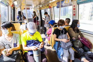 Tayvan 'ın Taipei kentindeki toplu hızlı ulaşım sisteminde kendilerini koronavirüsten (COVID-19) korumak için yüz maskesi takan yolcular. 