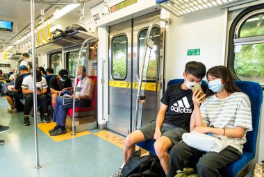 Tayvan Demiryolu İdaresi 'nin hızlı treninin kabinlerinde, yolcular kendilerini yeni koronavirüsten korumak için maske takarlar (COVID-19).