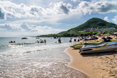 Pingtung, Tayvan 'daki Kenting Ulusal Parkı' ndaki Chuanfanshi Sahili yakınlarındaki plajda oynayan turistler