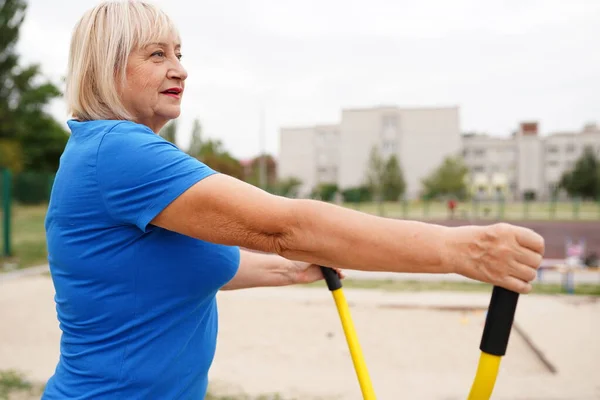 beautiful healthy woman 64 years old doing exercises outdoors