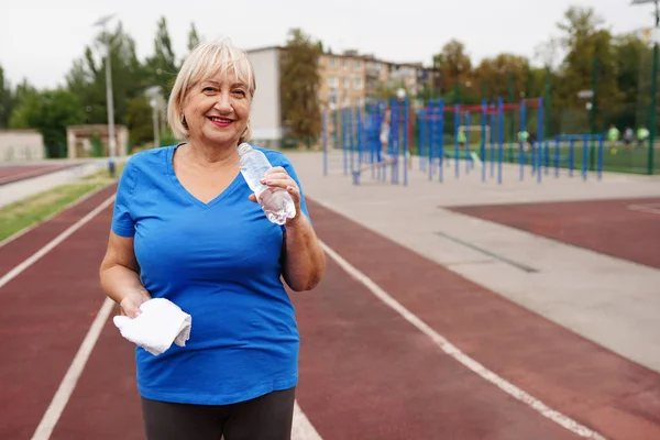 Su şişeli iki kadın gülümsüyor. Kıdemli hanımlar dışarıda. Yeni aerobik eğitim programı